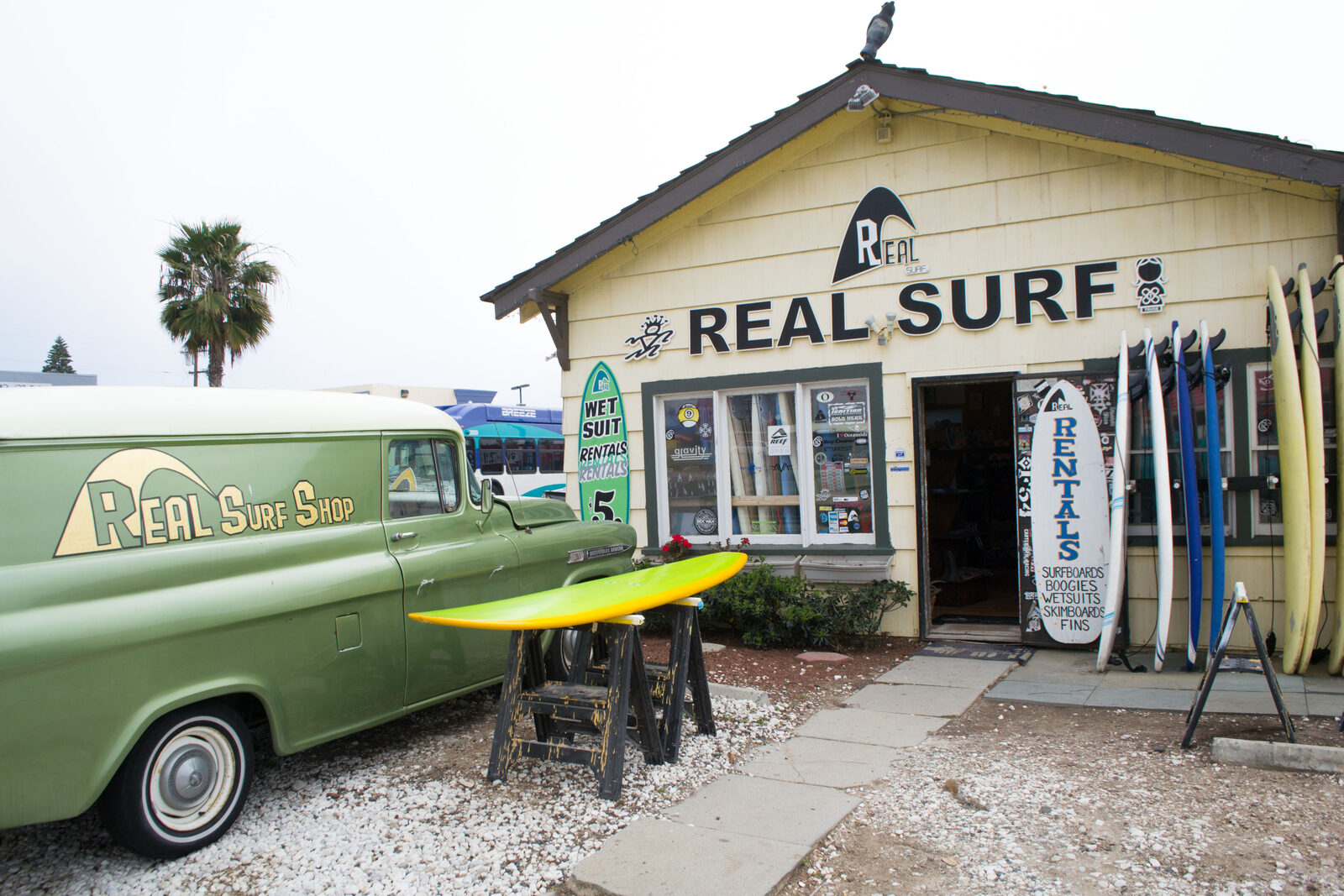 A rack of boards at a surfboard rental shop — the gear a lesson may or may not include