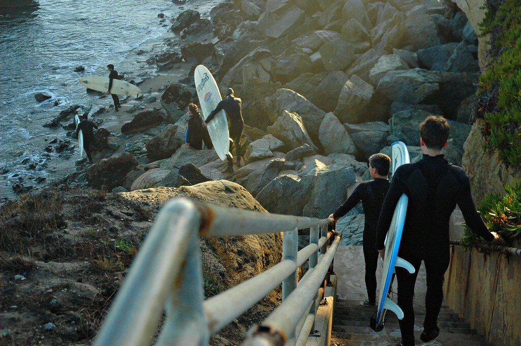 Surfers walking down to the water with their boards for a booked morning session